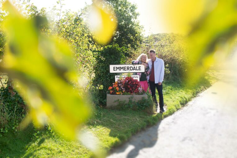 Guests standing next to the Emmerdale sign on the Emmerdale Tour